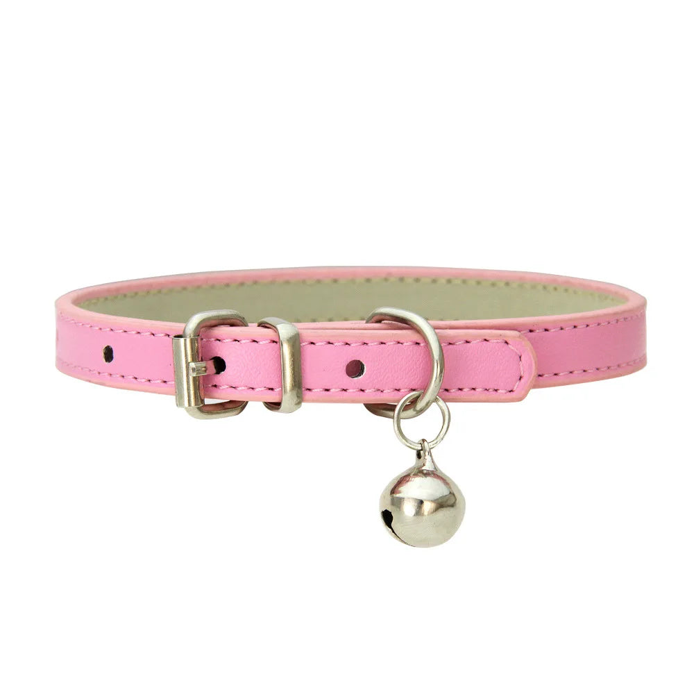 Collier en cuir rose avec une clochette argentée sur fond blanc

