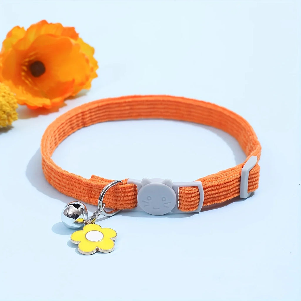 Collier orange avec une étiquette jaune en forme de fleur sur fond bleu clair

