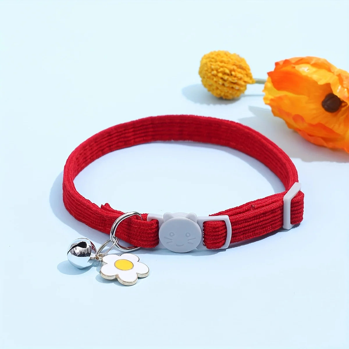Collier rouge avec une médaille en forme de fleur sur fond bleu clair

