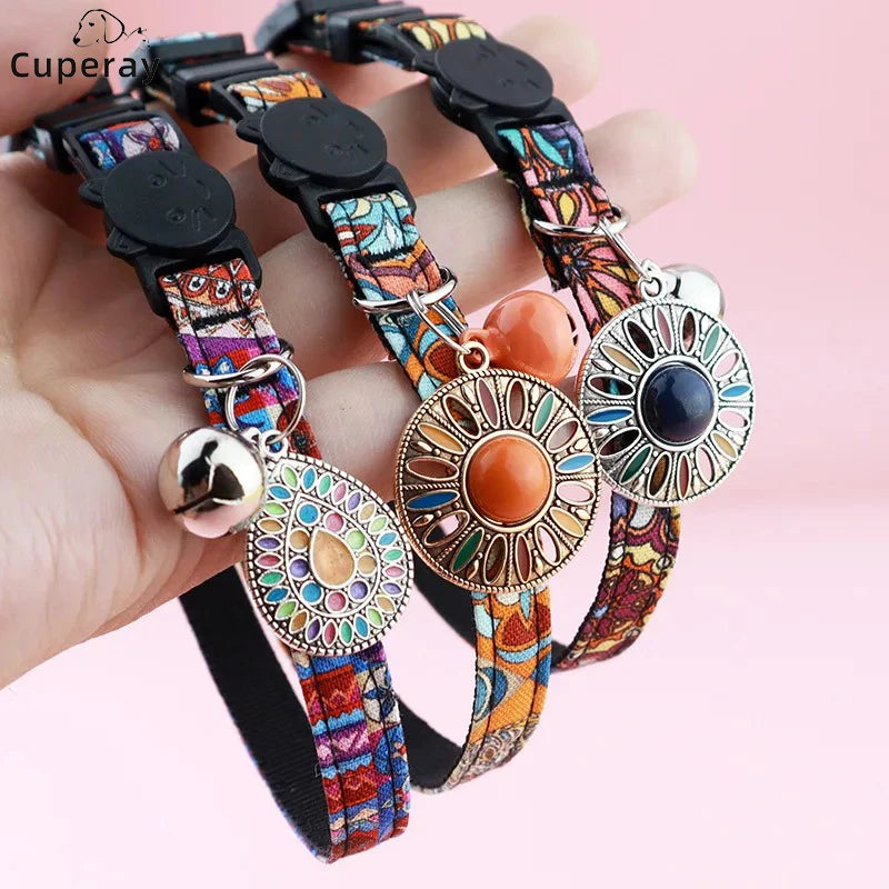Colliers colorés avec des éléments décoratifs tenus par une main sur un fond rose

