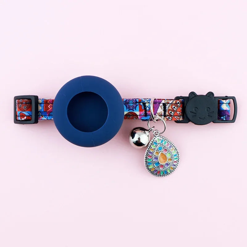 Collier pour chat avec motif coloré, clochette bleue et charme décoratif sur fond rose

