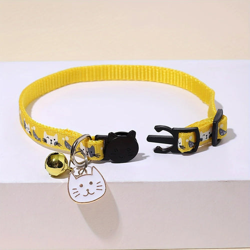 Collier jaune pour chat avec une clochette et une médaille en forme de chat sur fond blanc

