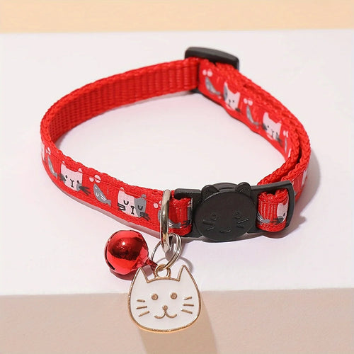Collier rouge pour chat avec une clochette et une médaille en forme de chat sur fond clair

