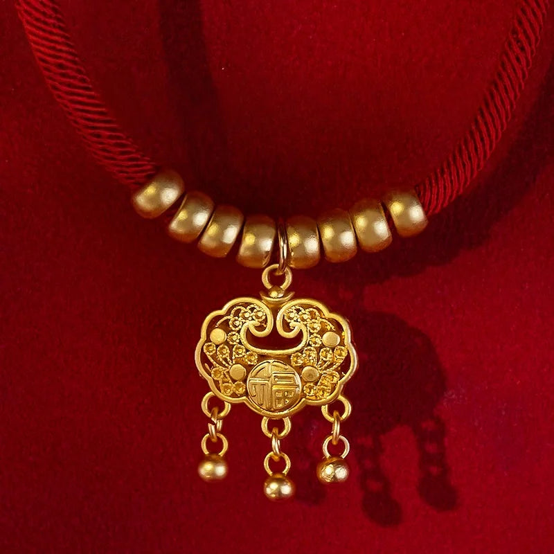 Gold necklace with a decorative pendant on a red background


