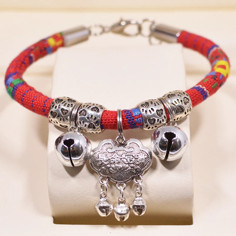Bracelet coloré avec des perles argentées et des breloques sur fond blanc

