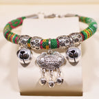 Bracelet perlé multicolore avec des breloques argentées sur fond blanc

