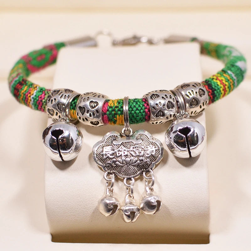 Bracelet perlé multicolore avec des breloques argentées sur fond blanc

