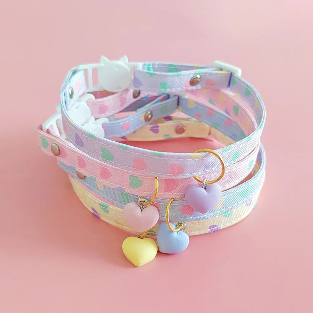 Collier à pois pastel avec pendentifs en forme de cœur sur fond rose

