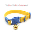 Collier pour chat bleu et jaune avec une clochette dorée sur fond blanc

