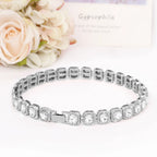 Bracelet en argent avec des pierres transparentes sur fond blanc et des fleurs
