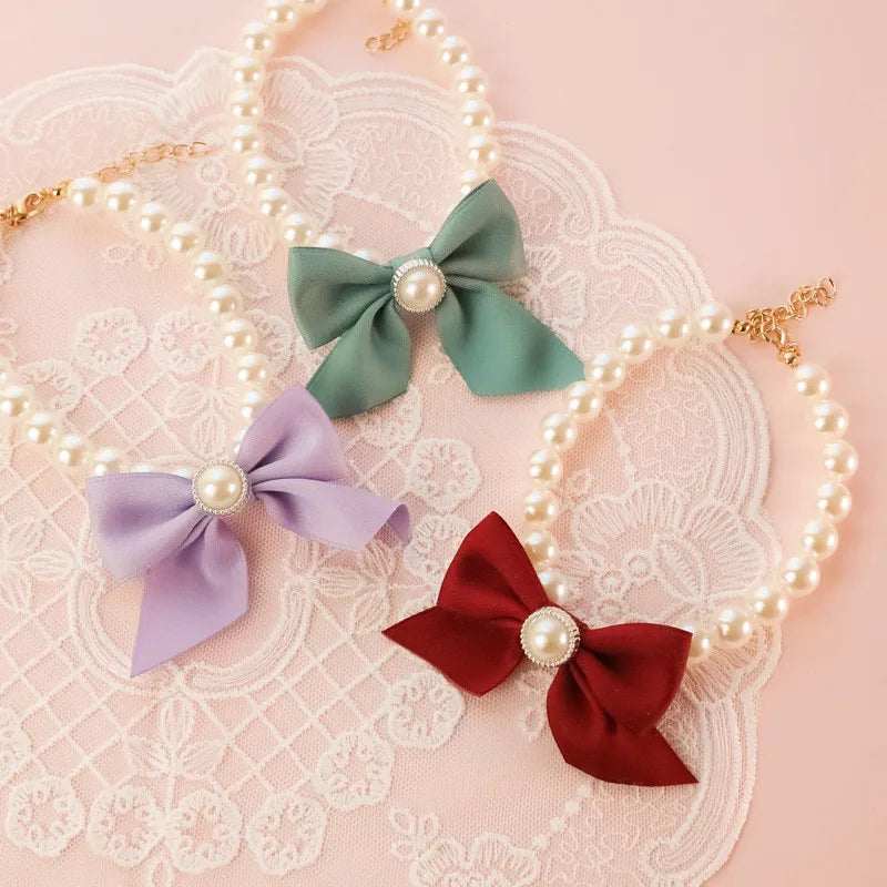 Trois nœuds en tissu avec des perles sur un fond décoratif en dentelle

