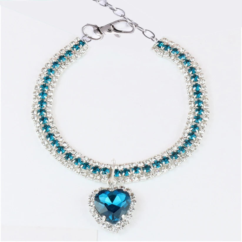 Bracelet avec une pierre en forme de cœur bleue et des pierres transparentes sur fond blanc

