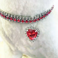 Bijoux avec une pierre précieuse rouge en forme de cœur sur fond blanc
