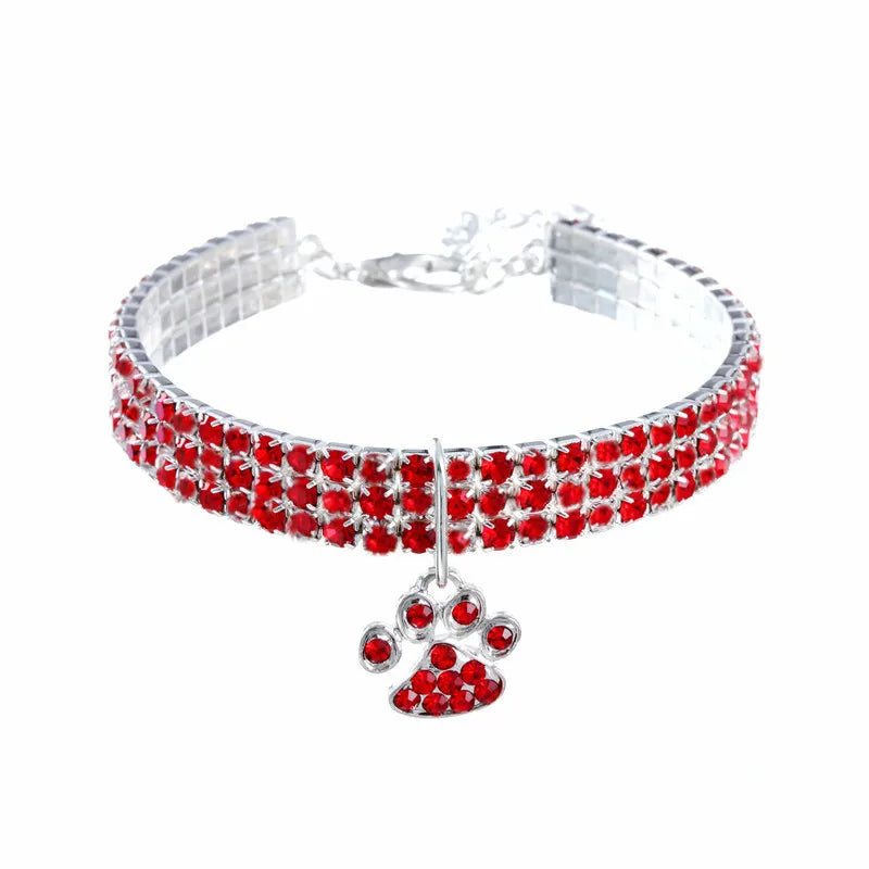 Collier ras-du-cou en argent avec pierres précieuses rouges et un pendentif de patte sur fond blanc

