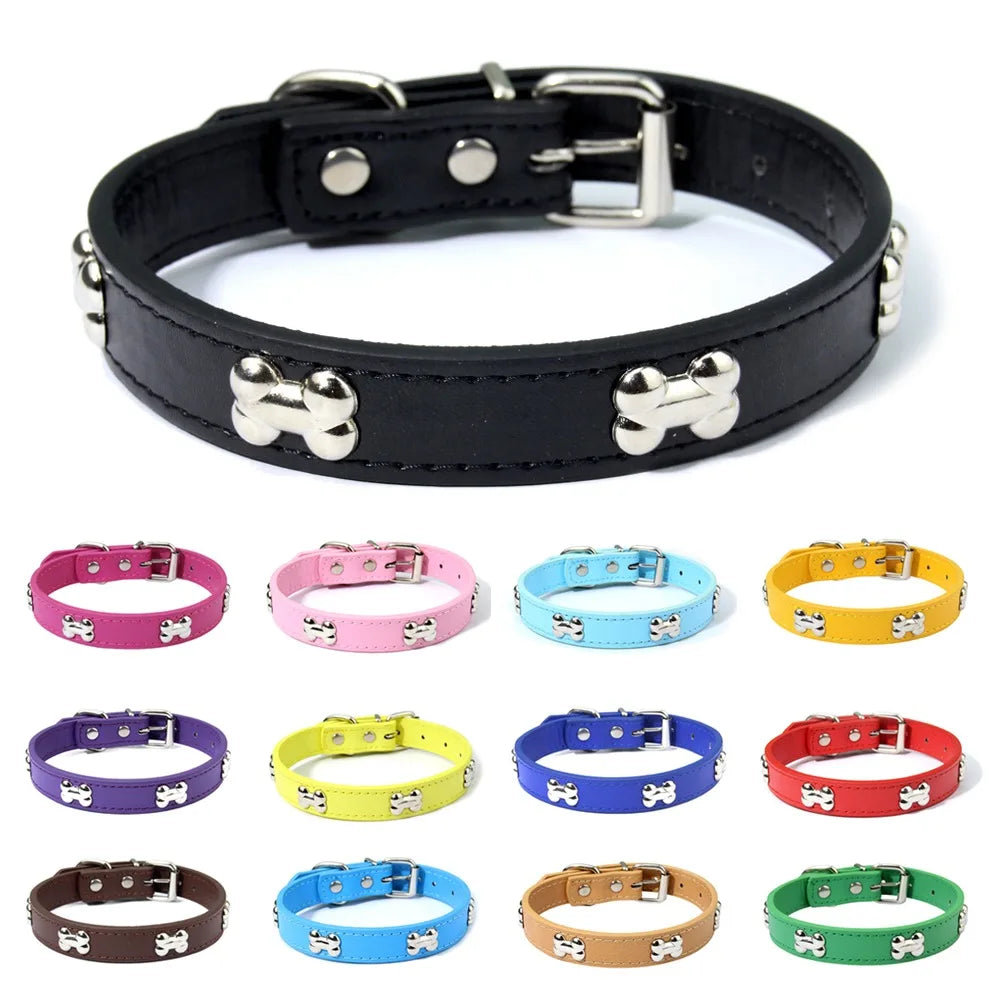 Collier en cuir noir pour chien avec des clous en forme d’os et une sélection de colliers colorés en dessous sur fond blanc.

