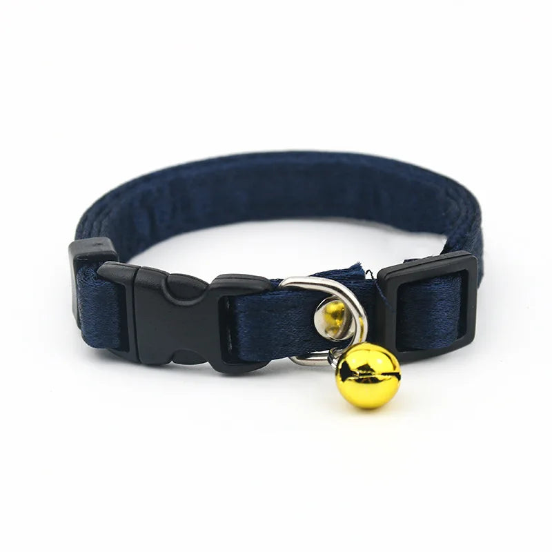 Collier bleu marine avec une clochette dorée sur fond blanc

