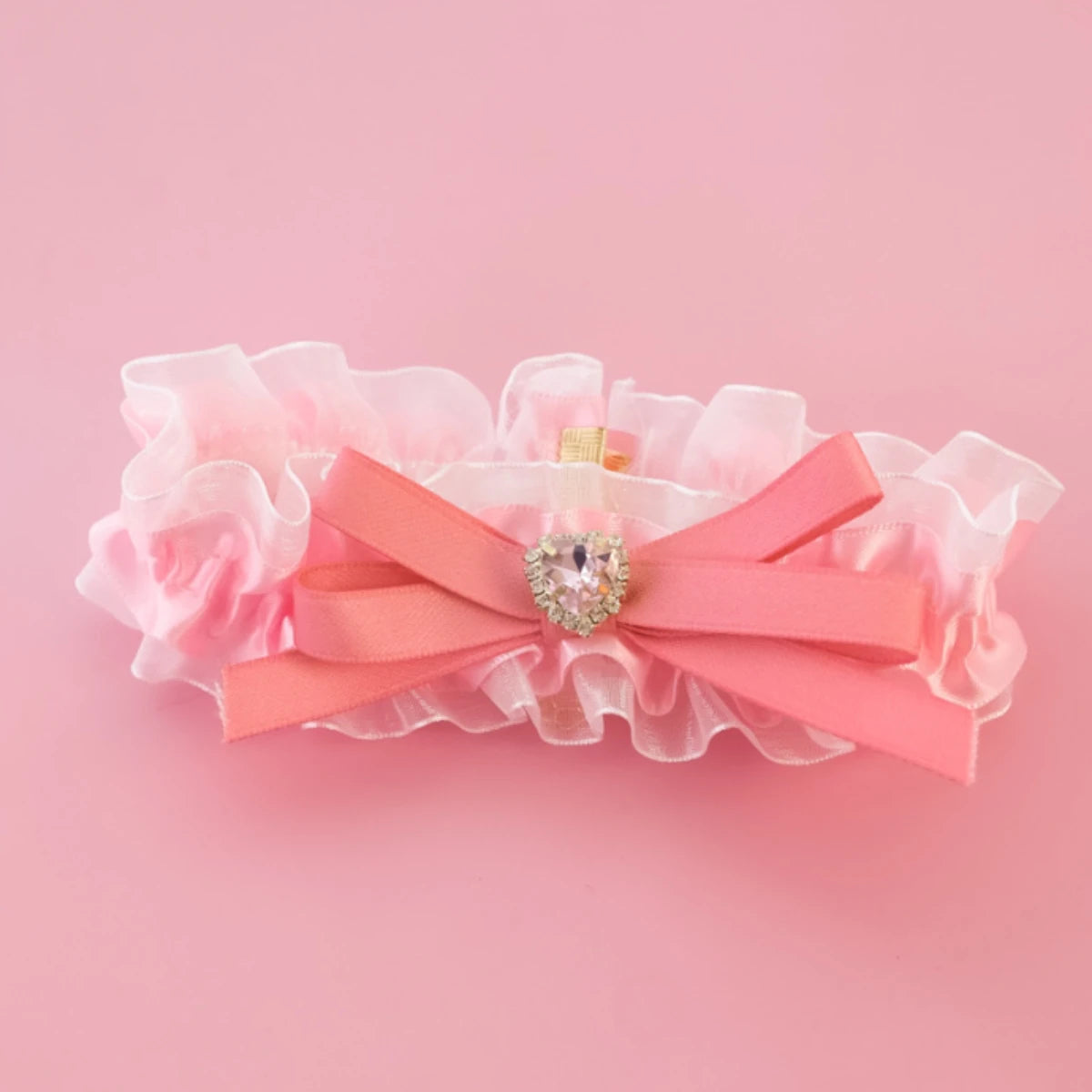 Bandeau rose avec un nœud et un élément décoratif sur fond rose

