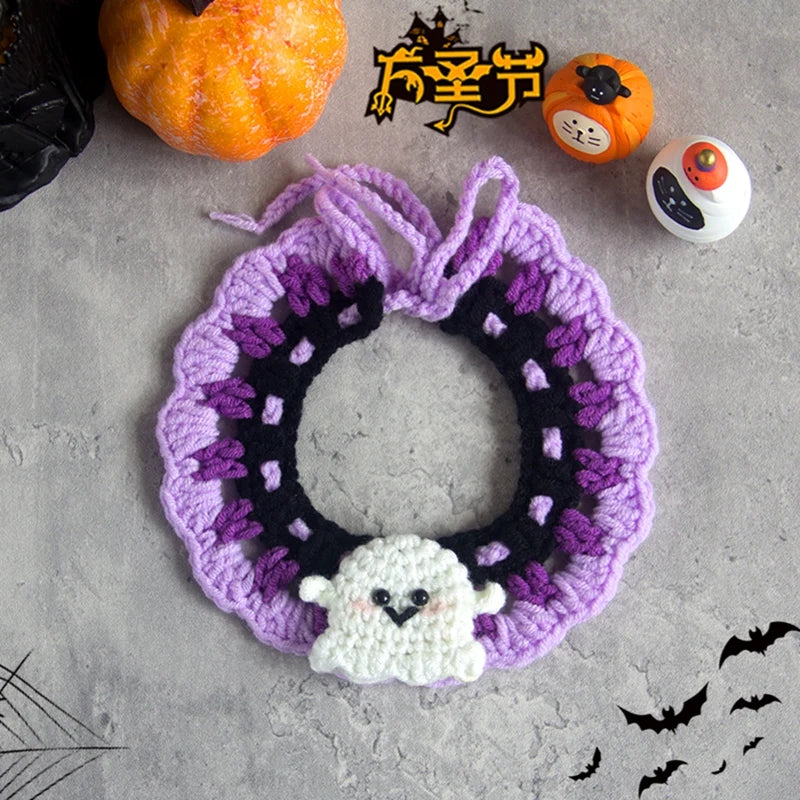 Couronne au crochet sur le thème d’Halloween avec une décoration fantôme sur une surface grise, entourée de citrouilles et de toiles d’araignée.

