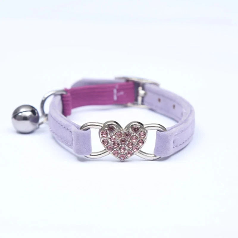 Collier pour animaux avec un breloque en forme de cœur et une clochette sur fond blanc

