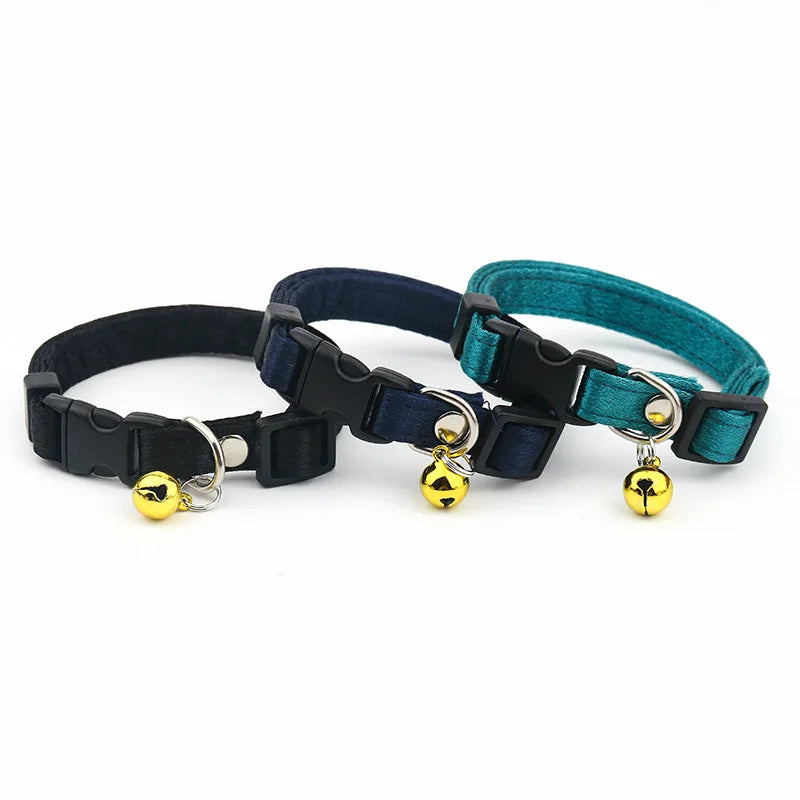Trois colliers pour chats avec des porte-bonbons de cloche sur fond blanc

