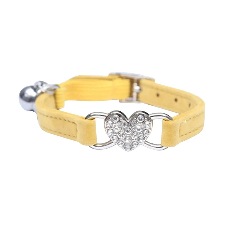 Collier jaune pour chat avec une boucle métallique en forme de cœur sur fond blanc

