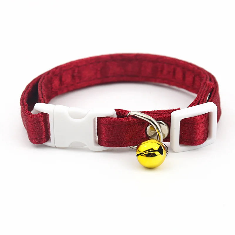 Collier rouge pour chat avec une clochette jaune sur fond blanc

