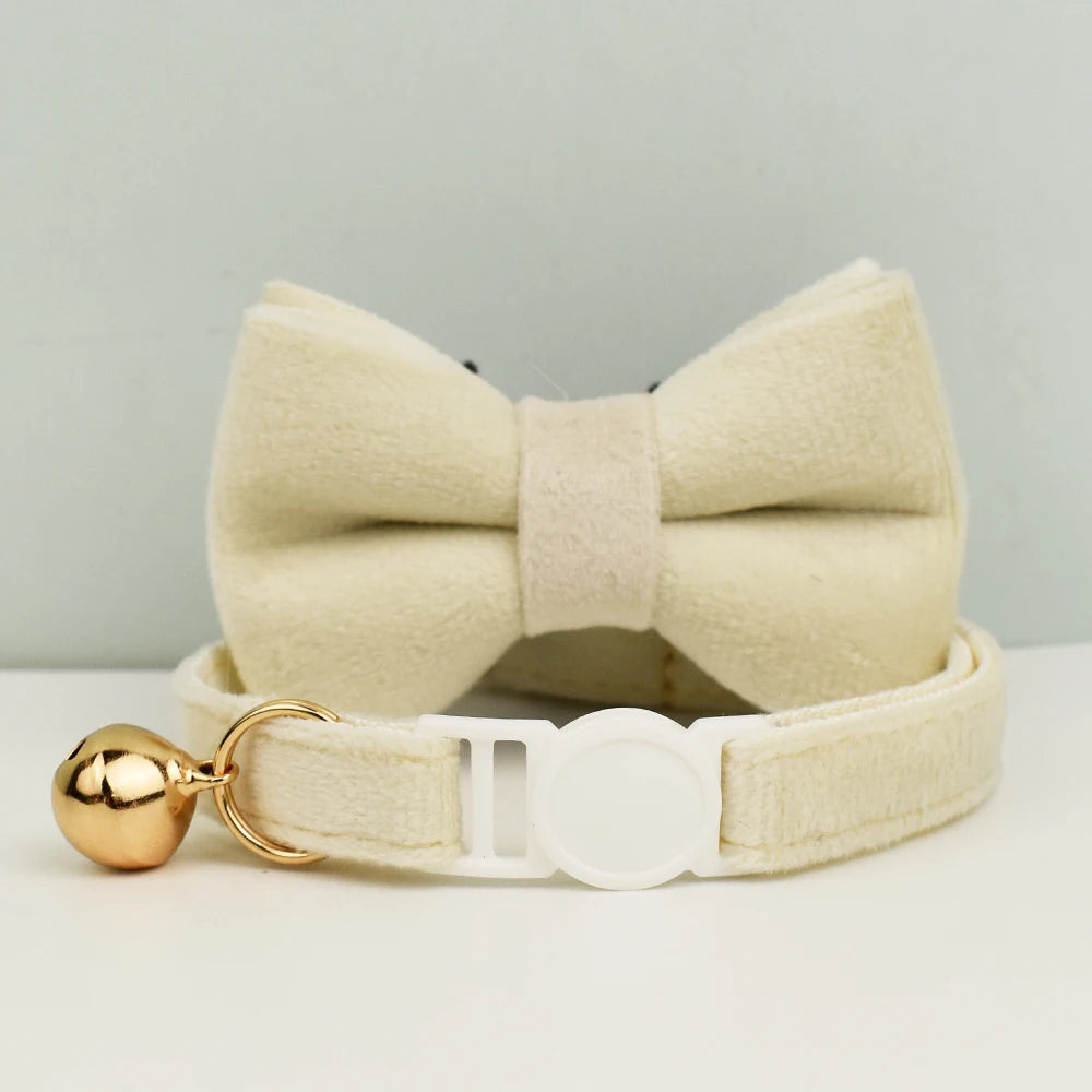 Nœud papillon et col beige serti avec un accent doré sur fond gris clair

