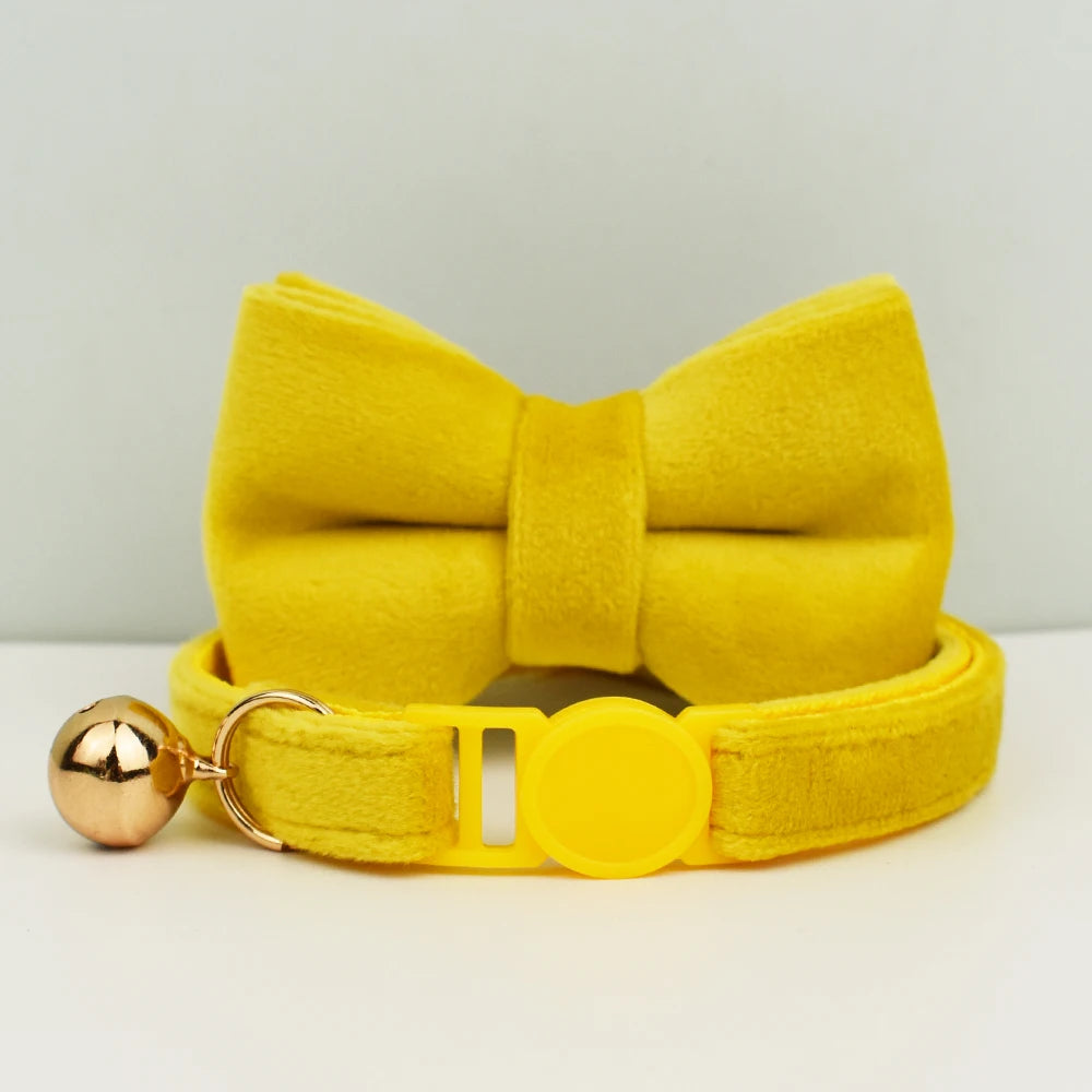 Collier jaune avec un grand nœud et une boule dorée sur fond clair
