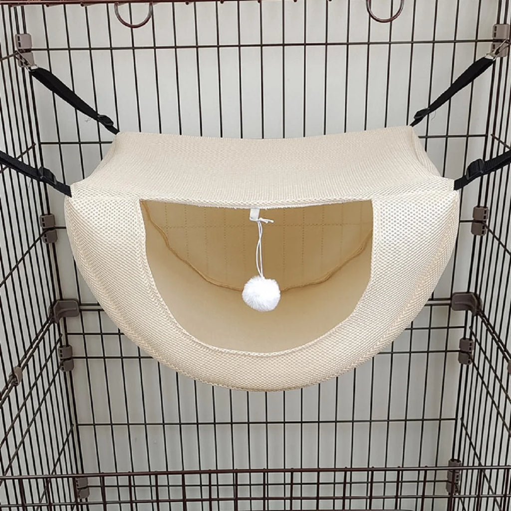 Hamac beige pour animaux avec une boule blanche suspendue à l’intérieur d’une cage en fil métallique
