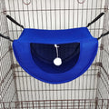 Hamac bleu pour animaux avec un pompon blanc suspendu à l’intérieur d’une cage en fil de fer.
