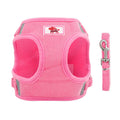 Harnais et laisse roses pour chien sur fond blanc
