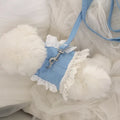 Petit sac bleu avec des détails en dentelle blanche sur une surface blanche et duveteuse
