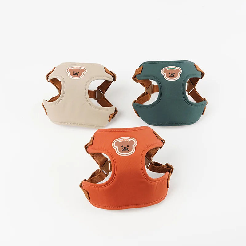 Trois harnais pour chiens beige, vert et orange sur fond blanc