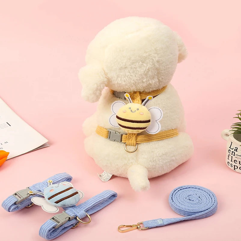 Mouton en peluche avec un harnais et une laisse à thème abeille, sur fond rose

