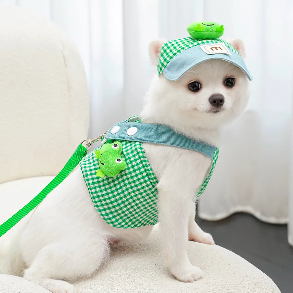 Petit chien blanc portant une tenue verte à carreaux décorée sur fond blanc

