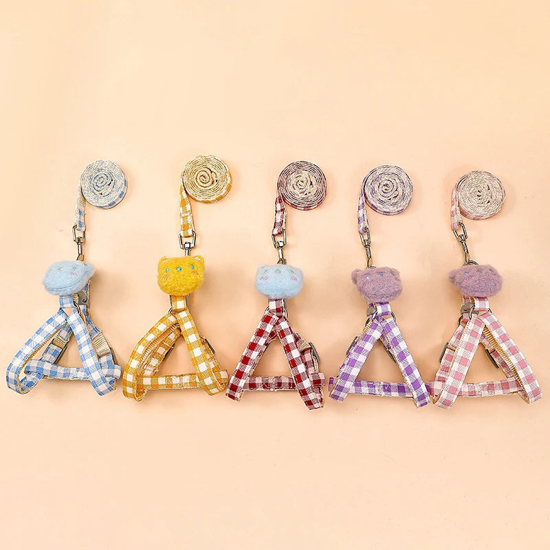 Cinq jouets colorés avec des motifs à carreaux et des pompons sur fond beige


