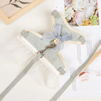 Harnais pour chien gris clair avec un nœud sur une surface blanche ornée de décorations florales

