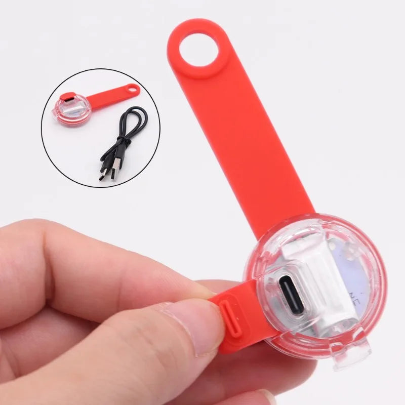 Protecteur de câble en silicone rouge avec une main qui le tient, montrant sa taille et son design.

